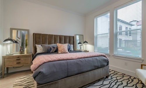 bedroom with nightstands and a large window