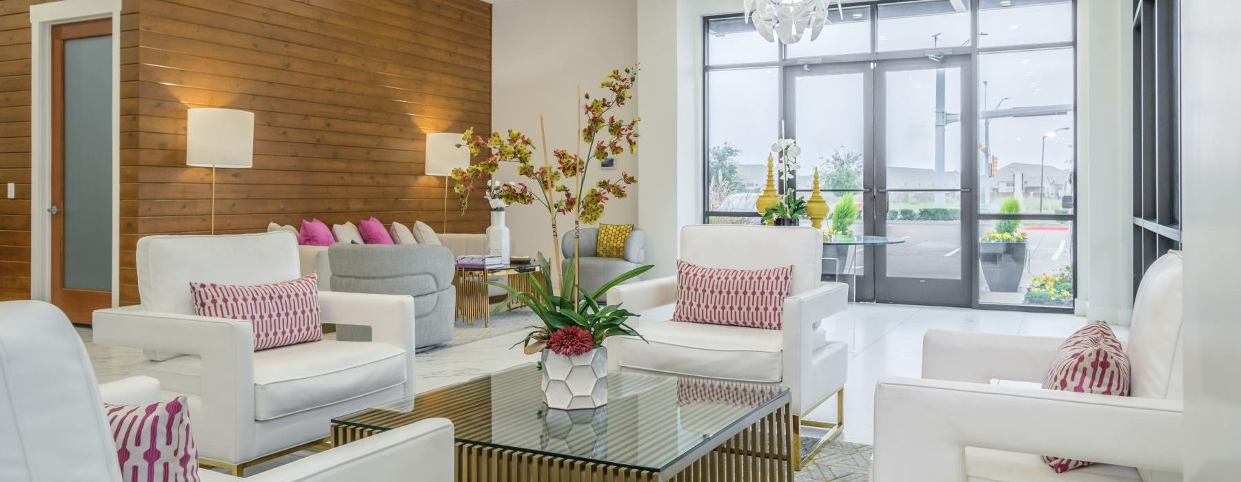 a living room with white couches and a glass table
