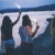 a group of girls holding sticks near the water
