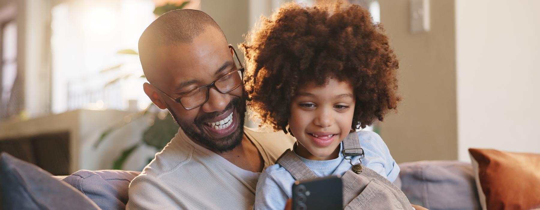 a man with a child looking at a phone